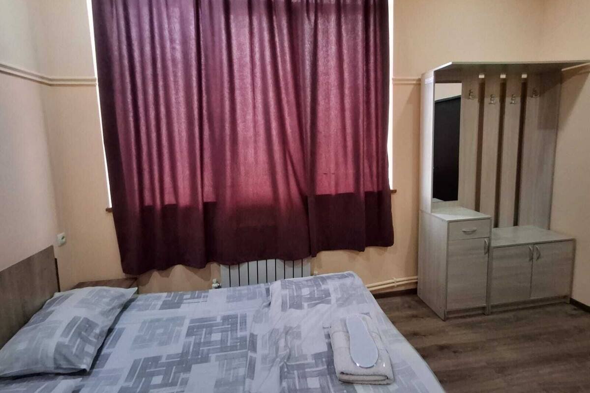 Ein Schlafzimmer mit Bett, Nachttisch, Spiegel und Kleiderschrank.