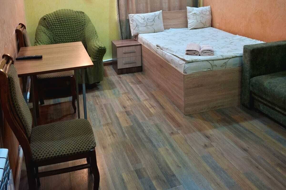 Ein Zimmer mit einem Bett, einem Schreibtisch, einem Stuhl und einem Nachttisch.