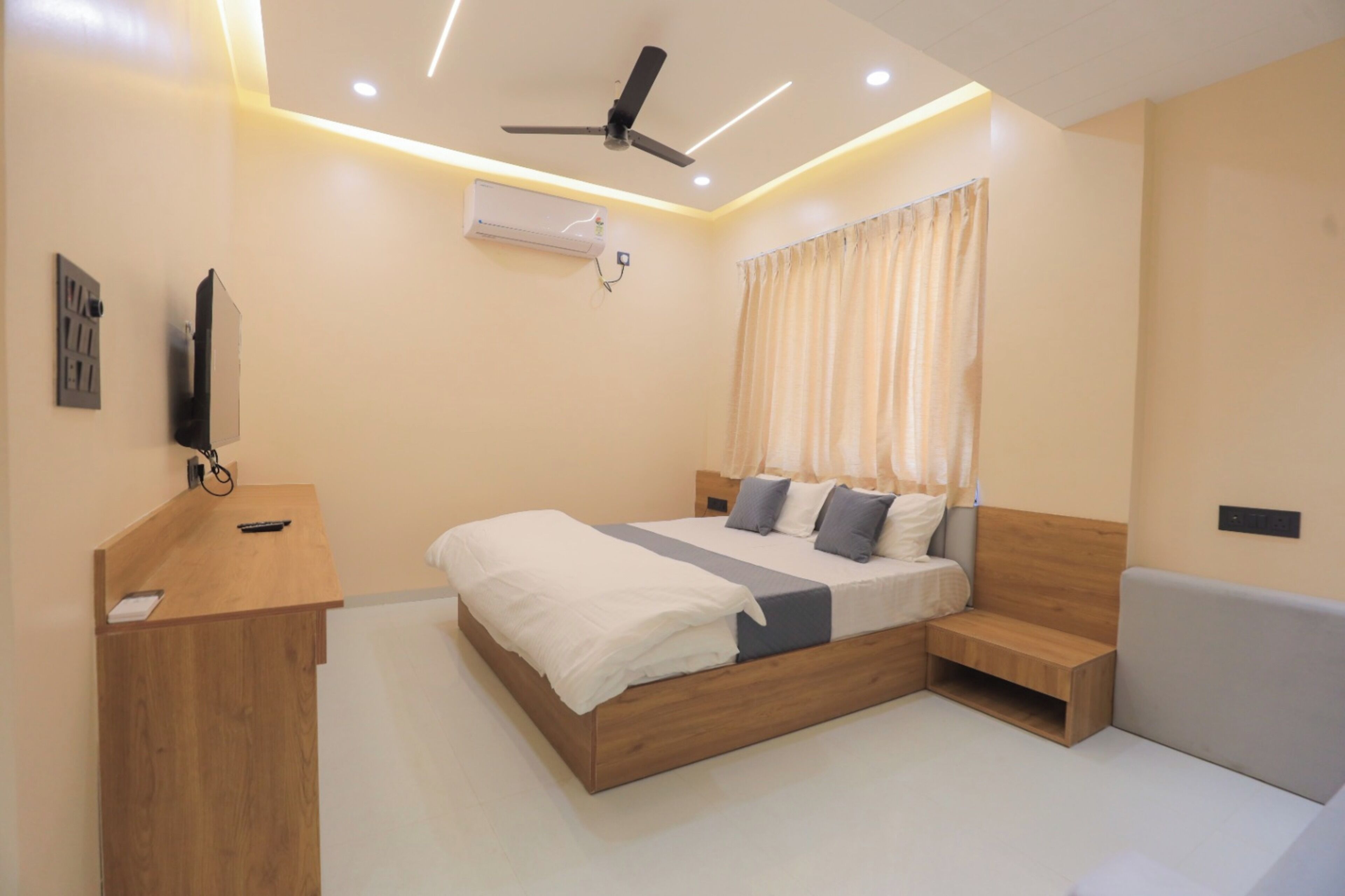 A modern bedroom with a bed, bedside table, and a small wooden bench.