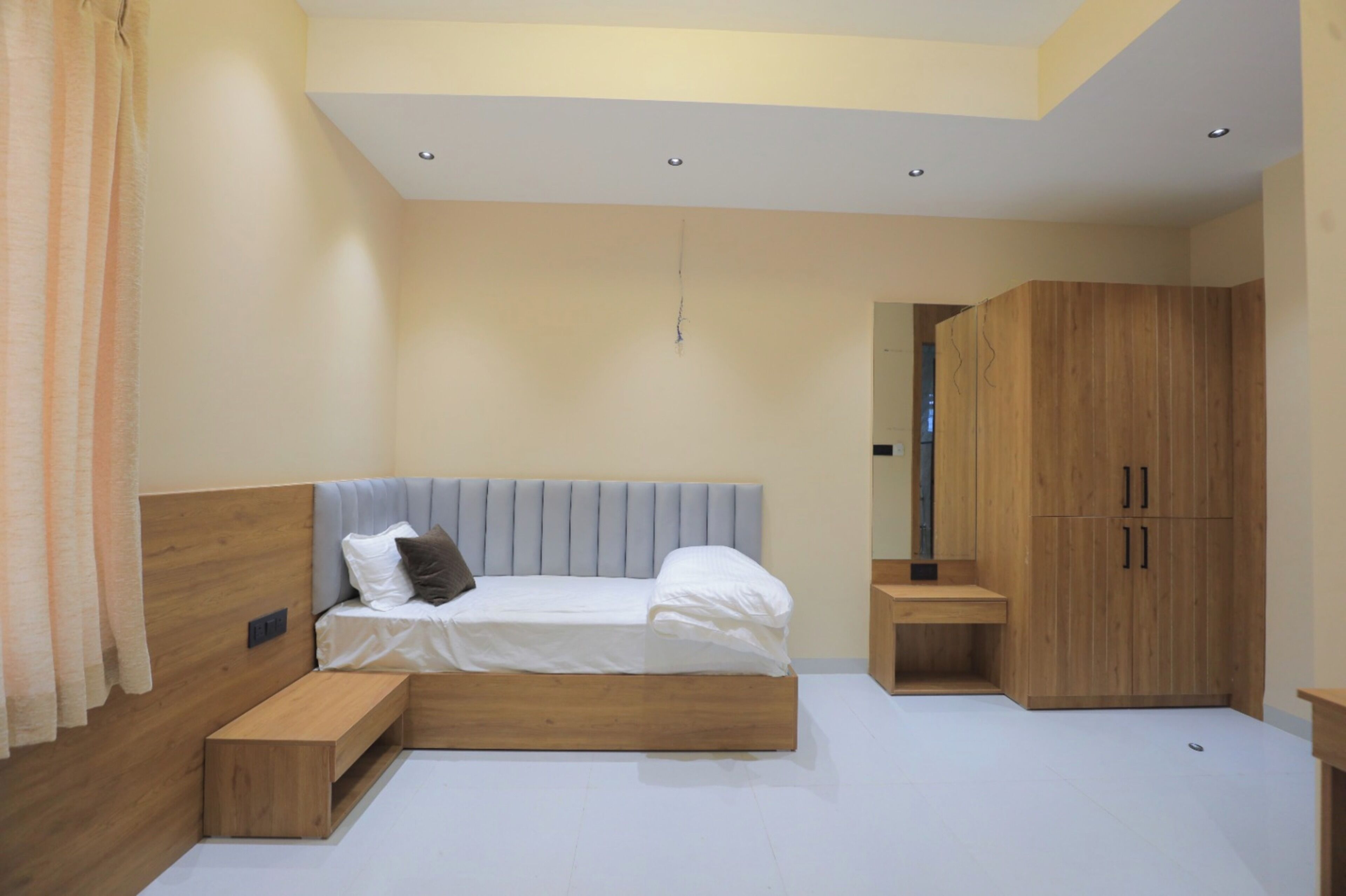 A modern bedroom with a bed, wooden wardrobe, and a bench.