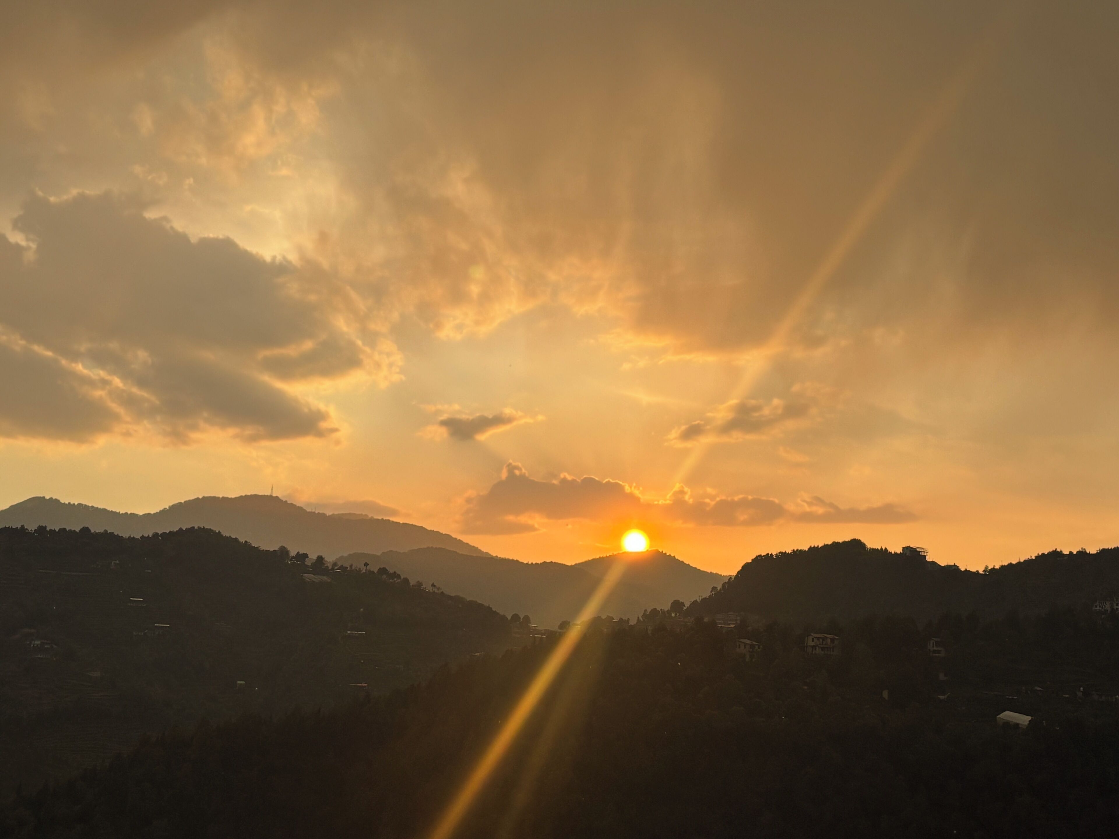 A sunset over a mountainous landscape with a clear sky.