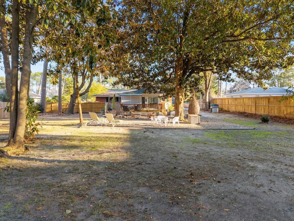A backyard with a patio area, outdoor furniture, and a house in the background.