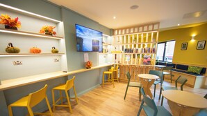 Un interior de restaurante con mobiliario de madera, un televisor y estantes con adornos.