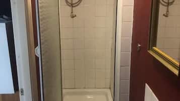 Une salle de bain avec une douche, un lavabo et un miroir.