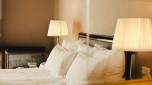 Une chambre d’hôtel avec un lit, deux lampes de chevet et une table de chevet avec une lampe.