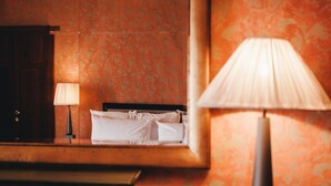 A hotel room with a bed, a nightstand, a lamp, and a wardrobe. - Red Room (Praiano)
