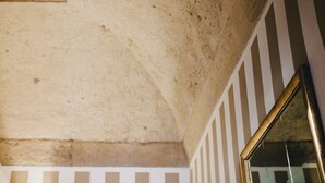 A textured ceiling with a visible crack, a striped wall, and a reflective surface. - La Grigia (Praiano)