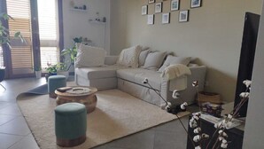 A living room with a sectional sofa, two ottomans, a coffee table, and a rug. - RESIDENCE VIA LECCE (Merine)