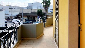 A balcony with a tiled floor, a door, and a railing. - RESIDENCE VIA LECCE (Merine)