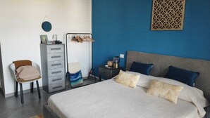 A bedroom with a bed, a chair, a dresser, and a nightstand. - RESIDENCE VIA LECCE (Merine)