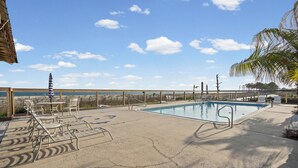 Zona de piscina amb gandules, una piscina i vista a l'oceà.