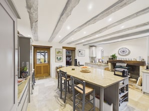 A kitchen with a central island, wooden beams on the ceiling, and a stone backsplash. - Charming house with pool for 8 people (Urval)