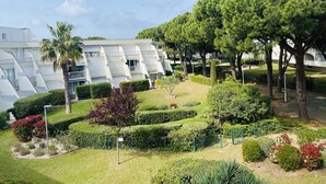 Ein modernes Gebäude mit einer geometrischen Fassade, umgeben von gepflegten Gärten und Bäumen.