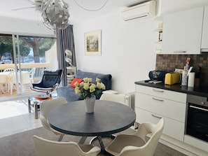 A modern kitchen with a dining area, a ceiling fan, and a view of the outdoors. - Apartment with AC and parking, sea view (Port Camargue)