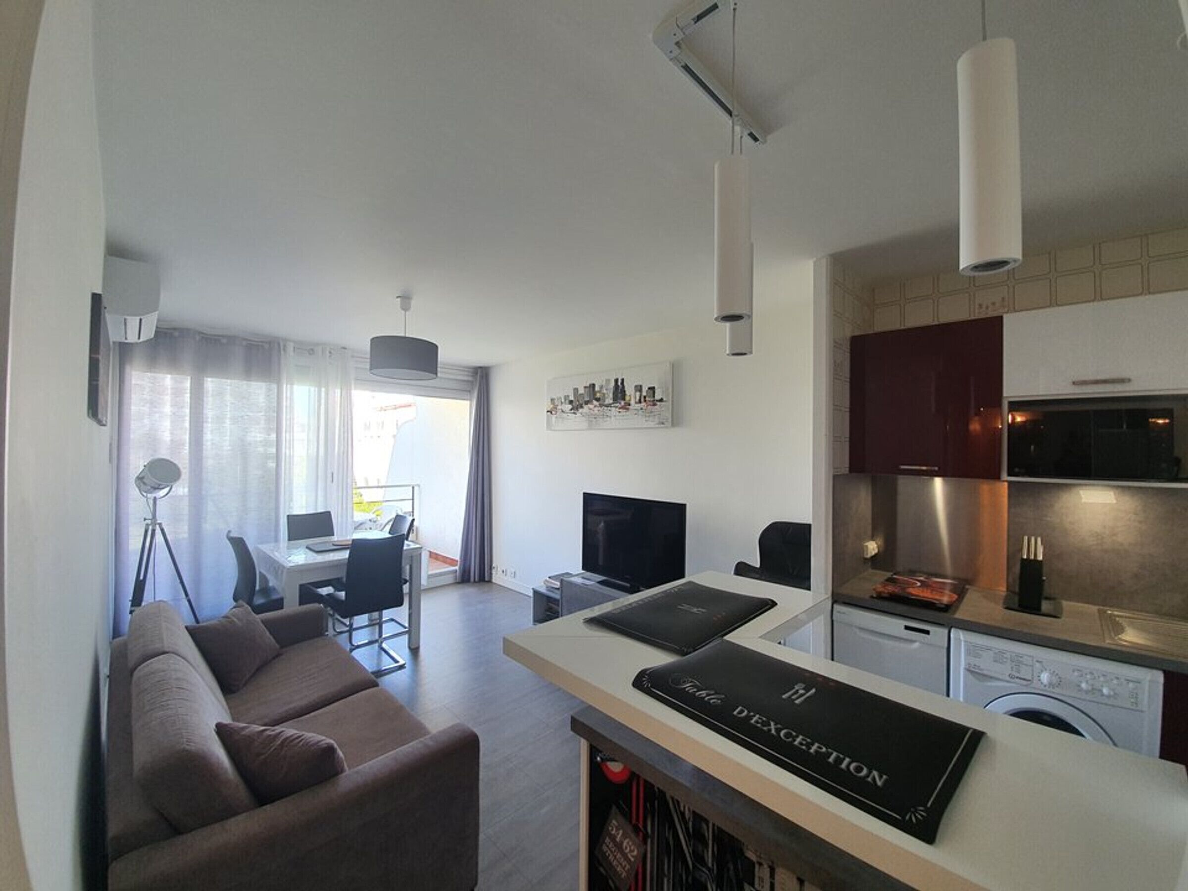 Un apartamento moderno con sala de estar, comedor, kitchenette y vistas a la ciudad.