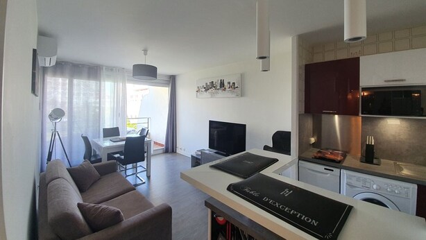 Un appartamento moderno con zona living, sala da pranzo, angolo cottura e vista sulla città.