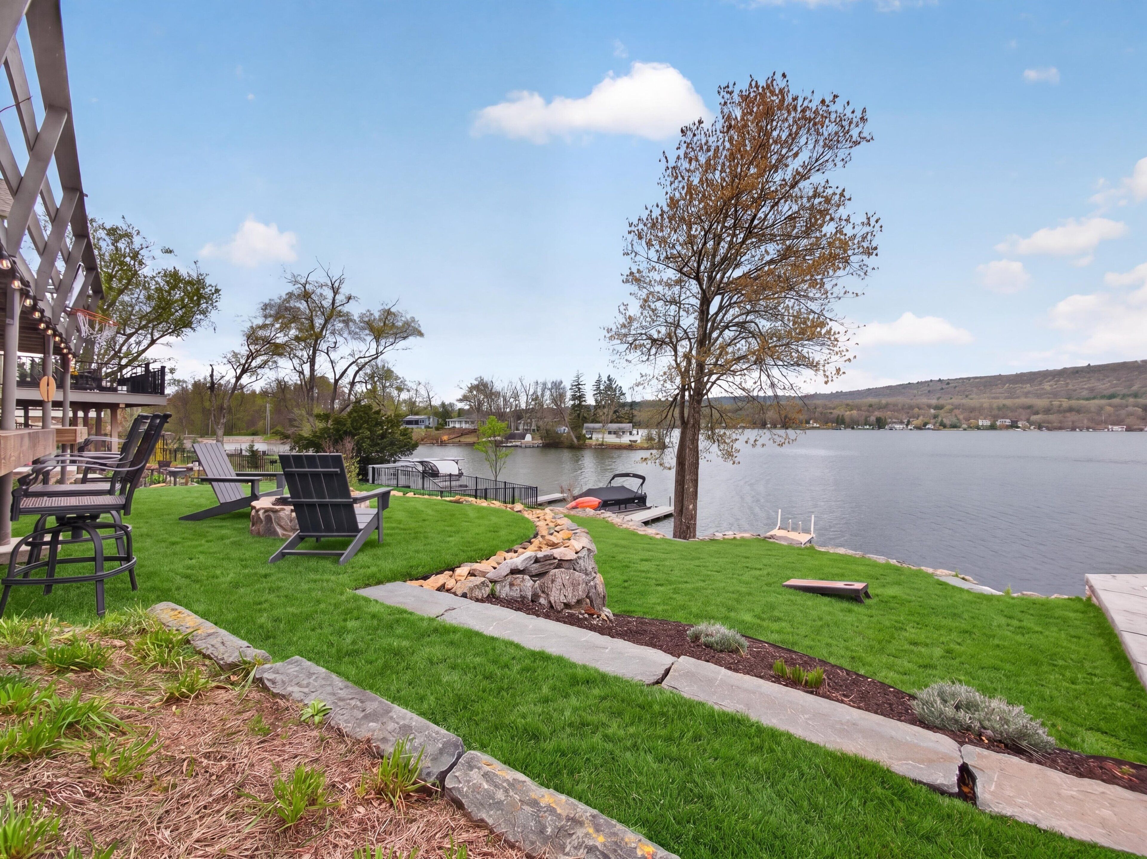 A lakeside patio with outdoor seating and a view of the lake.