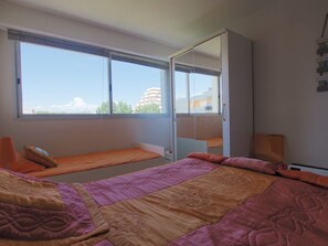 Ein Schlafzimmer mit einem Bett, einem Fenster und einer Schiebetür.