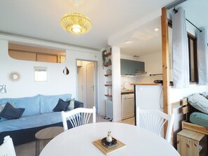 A compact living space with a sofa, dining table, and kitchenette. - Apartment with AC, parking - 5 guests (La Grande-Motte)