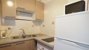 Eine Küche mit Spüle, Herd, Backofen und Kühlschrank.