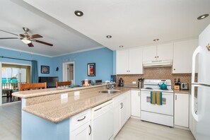 A modern kitchen with white cabinets, a granite countertop, and a built-in oven.