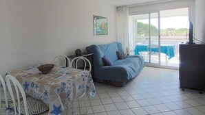 Habitació amb un llit, taula amb mantell estelat, cadira, televisió i vista a l'exterior.