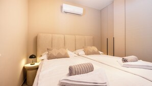 A hotel room with a bed, a nightstand, an air conditioning unit, and a wardrobe. - Villa Merkur -apartment 1 (Makarska)
