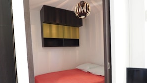 A bedroom with a bed, a television, and a pendant light. - Apartment with pool and parking - 4 guests (La Grande-Motte)