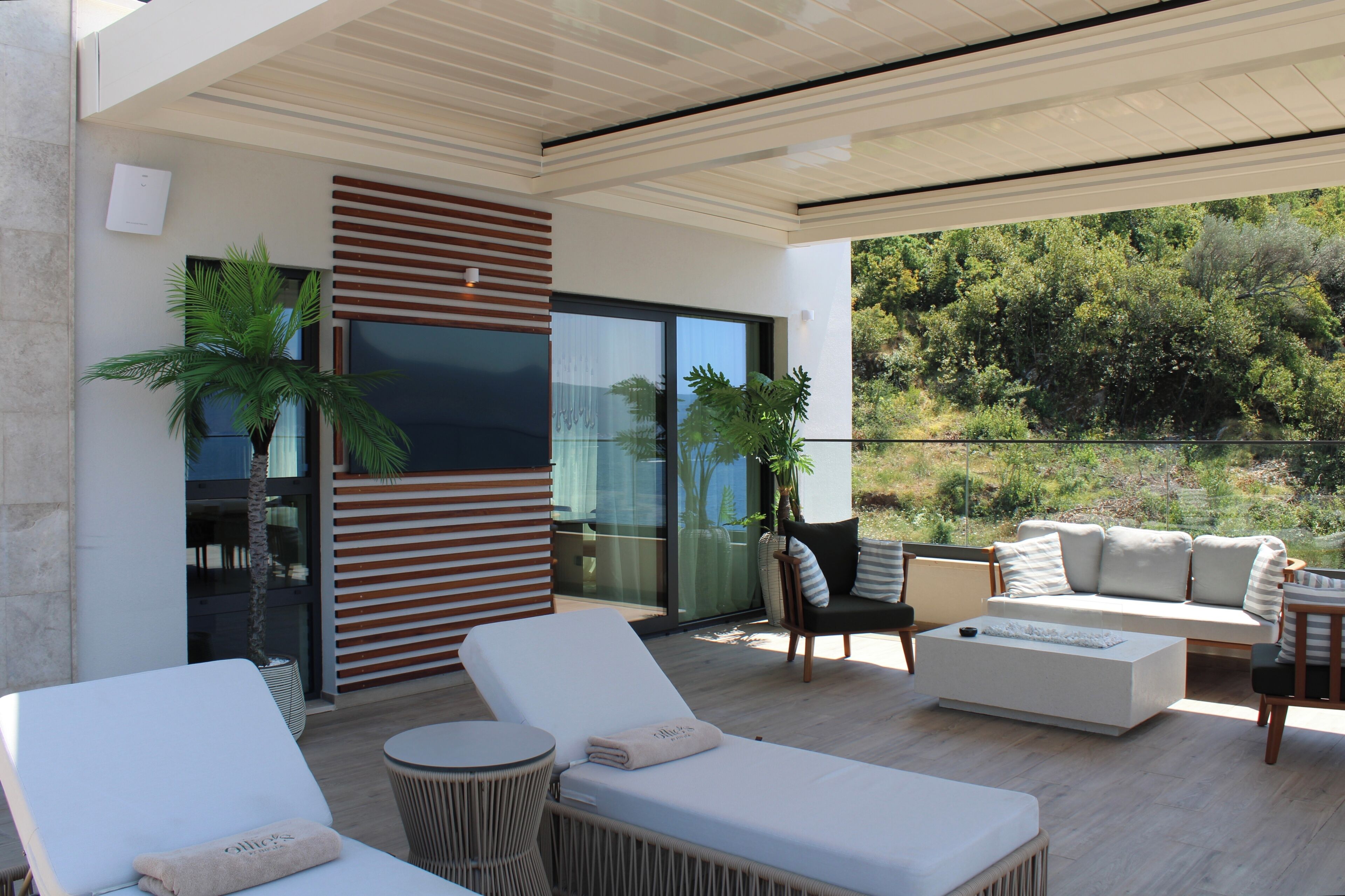 Un espacio al aire libre moderno con sillones, un sofá y una mesa de comedor.