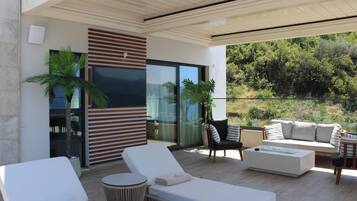 Un espacio al aire libre moderno con sillones, un sofá y una mesa de comedor.