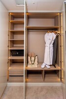 Vestidor con estantes de madera, una bata y un bolso.