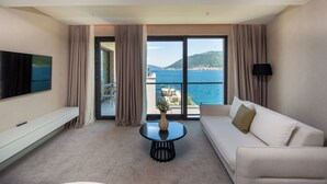 Une chambre d’hôtel moderne dotée d’une grande fenêtre, d’un canapé, d’une table basse et d’un téléviseur à écran plat.