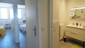A modern bathroom with a mirror, sink, and toilet. - Air-conditioned apartment, parking, sea view - 6 guests (Le Grau-du-Roi)