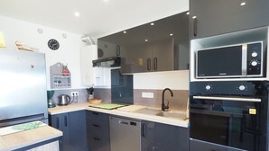 A modern kitchen with stainless steel appliances, a dishwasher, and a microwave. - Air-conditioned apartment, parking, sea view - 6 guests (Le Grau-du-Roi)