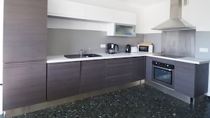 A modern kitchen with a built-in oven, microwave, and coffee maker.