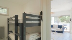 Een slaapkamer met stapelbedden en uitzicht op een terras.
