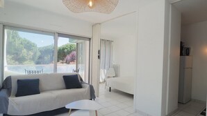 Een moderne woonkamer met een bank, een bijzettafeltje en een plafondlamp.