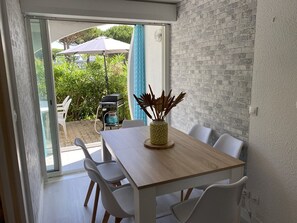 Ein Essbereich mit Tisch, Stühlen und Blick ins Freie.