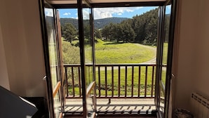 A room with a sliding glass door leading to a balcony with a view of a green landscape and trees. - 120 La Molina · Panoramic Views 5 Minutes From La Molina Ski Resort (Alp)