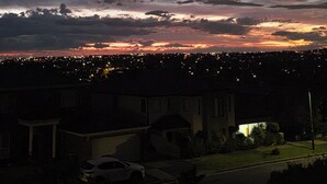 Un quartier résidentiel au crépuscule, avec des maisons et une rue.