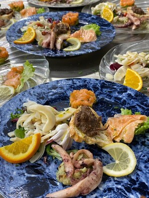 A variety of dishes on plates, including seafood and salads.