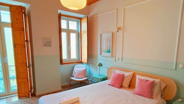 Camera da letto con un letto grande, soffitto in legno e una finestra.