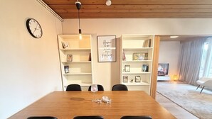 A dining area with a wooden table, black chairs, a clock, and shelves with books and decor. - Relaxing Riverside House with Sauna & Fireplace (Kannus)
