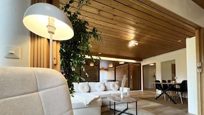 A modern living room with a sofa, coffee table, and dining area. - Relaxing Riverside House with Sauna & Fireplace (Kannus)