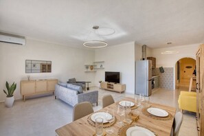 Eine moderne Wohnung mit Essbereich, Wohnzimmer und Küche.