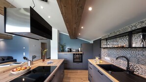 Eine moderne Küche mit Holzboden, integrierten Geräten und einer dekorativen Rückwand.