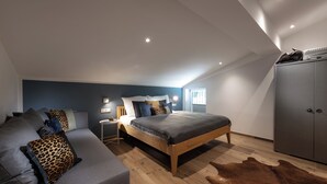 Ein Schlafzimmer mit Bett, Sofa, Kleiderschrank, Nachttisch und Teppich.
