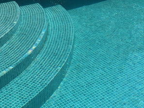 A pool with a geometric tile pattern and a curved edge.