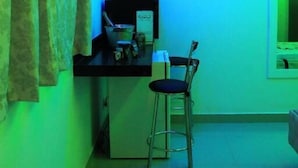 A room with a desk, chair, and a television mounted on the wall. - Motel hotel Vitória  (Rialma)