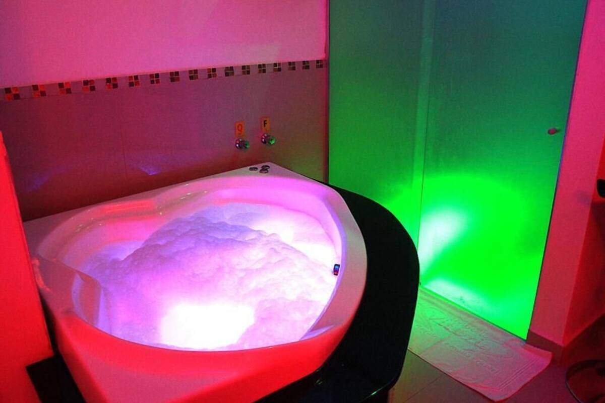 Una bañera con pantalla digital, pared de azulejos y una puerta.